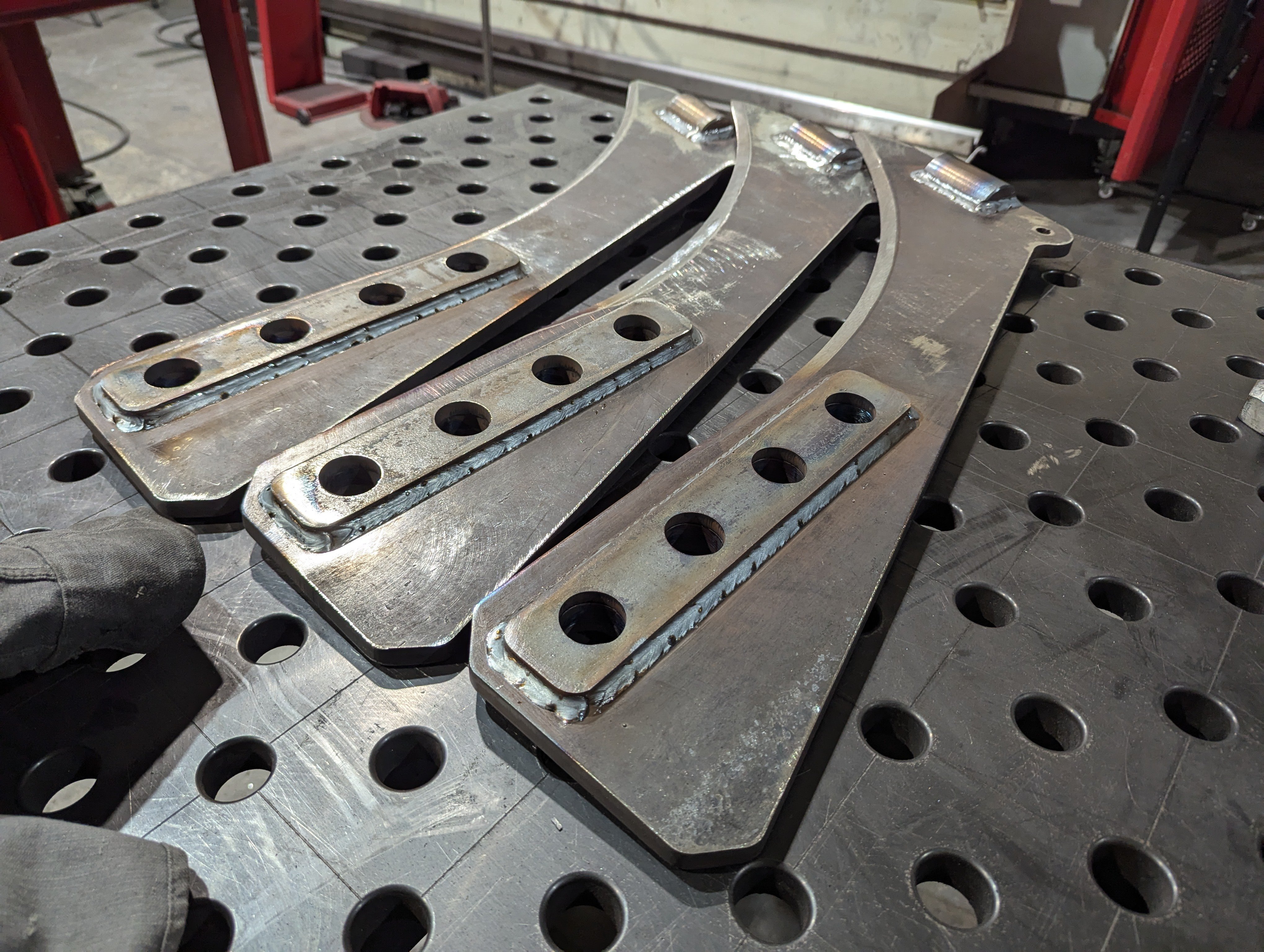 Three Case IH Dirt vibratory blow blades viewed from the top down, while they're laying flat.